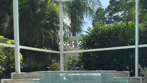 On voit clairement une piscine avec un bord carrelé et une cascade.