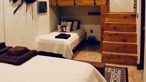 A room with a bunk bed, a desk, and a staircase. - Cowboy corral 2 (Brenham)