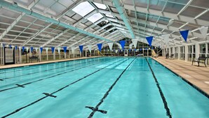 An indoor swimming pool with clear lanes, a covered roof, and benches along the sides. - Condo on Lake Keowee w/ Resort Amenities & Pool! (Salem)