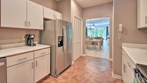 A modern kitchen with white cabinets, a stainless steel refrigerator, and a coffee maker. - Condo on Lake Keowee w/ Resort Amenities & Pool! (Salem)