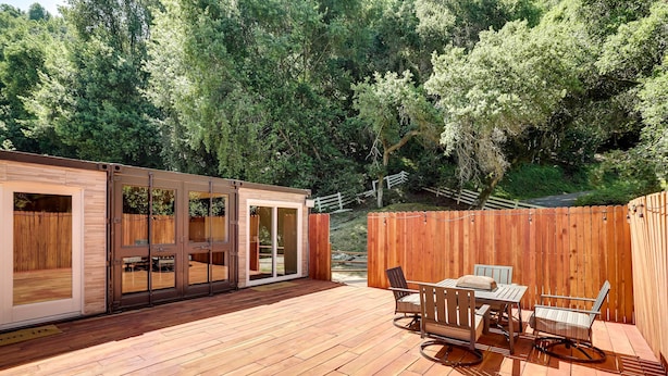 A wooden deck with a dining area and sliding glass doors leading to a room. - Unique Castro Valley House 30 Mi to San Fran! (Castro Valley)