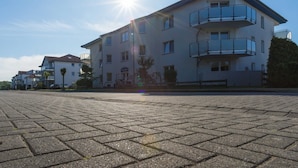 A multi-story building with a flat roof, balconies, and a paved ground. - Double room PK2005 - Pension Maiglöckchen (Karlshagen)