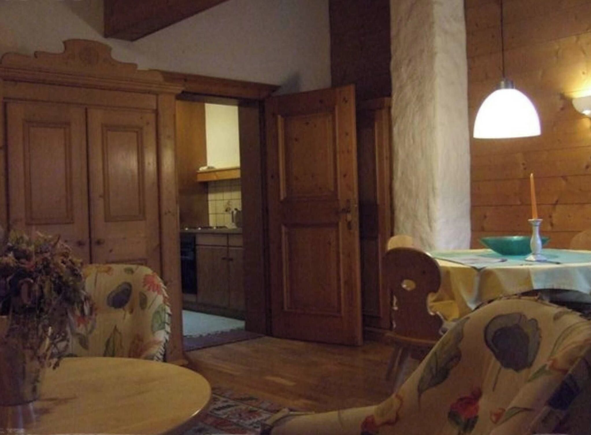 Une pièce chaleureuse, meublée de meubles en bois, avec une table à manger et une vue sur la cuisine.