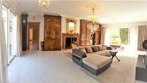 Una sala de estar amplia con un sofá modular grande, una chimenea y un candelabro.