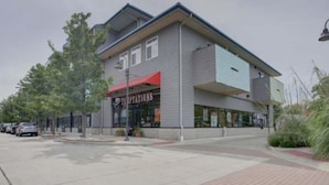 A two-story building with a storefront labeled "TEAPOTIONS". - Two bed two bath plus loft condo in Grand Haven (Grand Haven)
