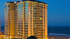 A multi-story hotel with a prominent "Ocean" sign, located near a beach with visible ocean views.