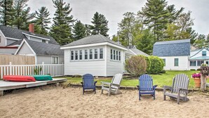 Une plage avec plusieurs chaises Adirondack et une terrasse en bois.