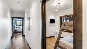 A modern room with a wooden ladder, a bed, a TV, and a window. - Modern Condo in Downtown Whitefish, Prime Location (Whitefish)
