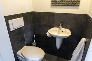Ein Badezimmer mit Toilette, Waschbecken und Handtuchhalter.