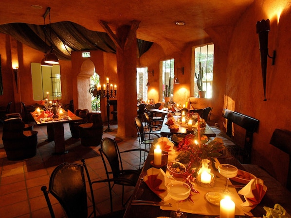 A restaurant with tables set for dining, candles, and a warm ambiance.