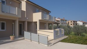 A multi-story residential building with balconies, a covered outdoor area, and a garden. - Cottage with barbecue on a plot of 2,500 sq.m. (Vinkuran)