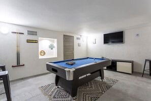 A pool table in a room with a window, a door, and a TV mounted on the wall. - Waterfront villa in Saint Maxime, Gulf of St Tropez (Sainte-Maxime)