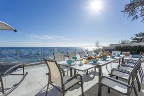 Un coin repas avec une table mise pour le petit-déjeuner, donnant sur la mer.