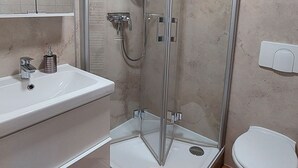 A bathroom with a shower, toilet, and sink.