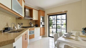 A modern kitchen with a large window, built-in oven, and stainless steel appliances.