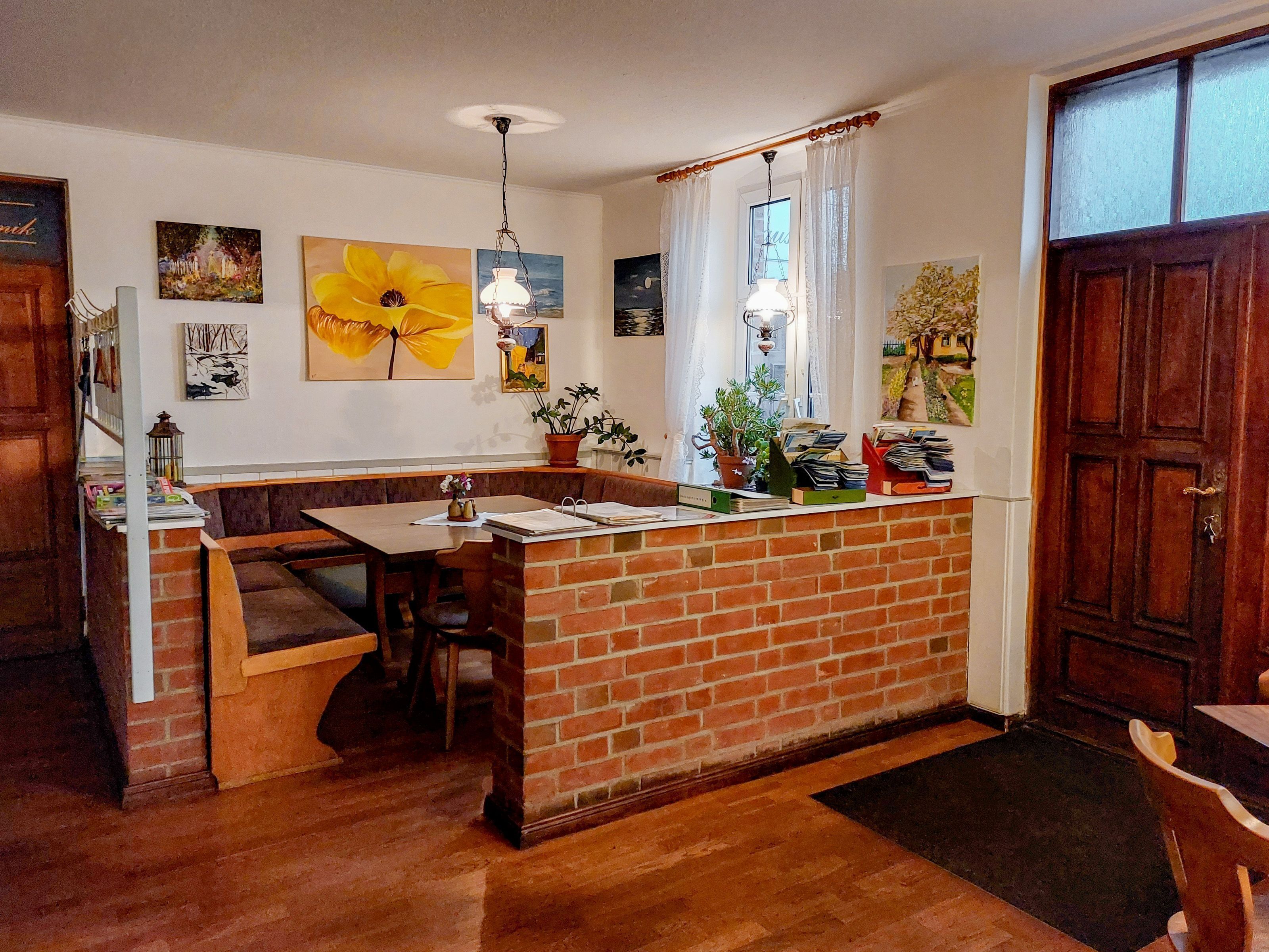 A kitchen with a brick island, wooden bench seating, and various kitchen appliances.