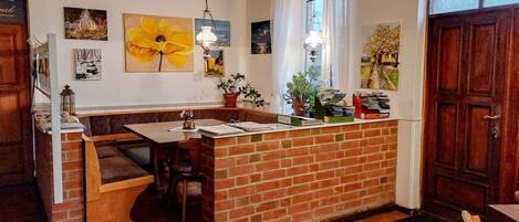 A kitchen with a brick island, wooden bench seating, and various kitchen appliances.