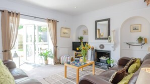A living room with a fireplace, comfortable seating, and a television.