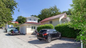 Asuinalue, jossa on taloja, parkkeerattuja autoja ja viheralueita.