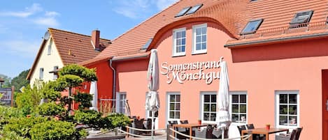 A building with a red facade and a sign that reads 'Sonnenstrand Monchgu.'