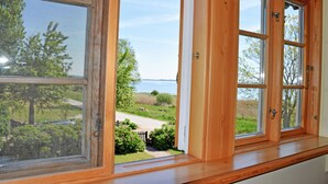Una ventana con vista a un área verde y un cuerpo de agua.