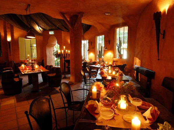 A restaurant with tables set for dining, candles, and a warm ambiance.