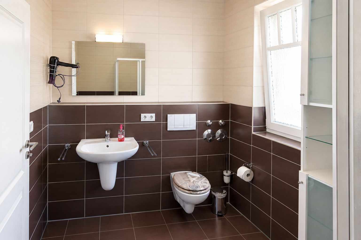 Un baño con lavamanos, inodoro y espejo.