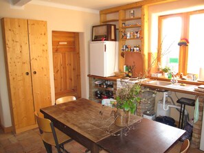 A kitchen with wooden cabinets, a refrigerator, a stove, and a sink.