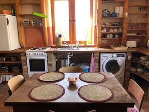 Eine kleine Küche mit Herd, Backofen, Spüle und Waschmaschine.