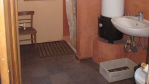 Un bagno con finestra, doccia, lavandino e WC.