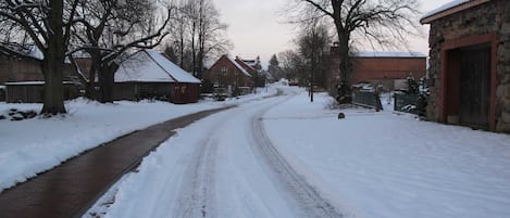 A snow-covered rural road with houses on either side.