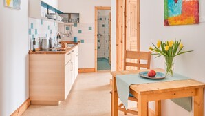 Una cocina moderna con encimera de madera, un lavabo y una zona de comedor con mesa y sillas.