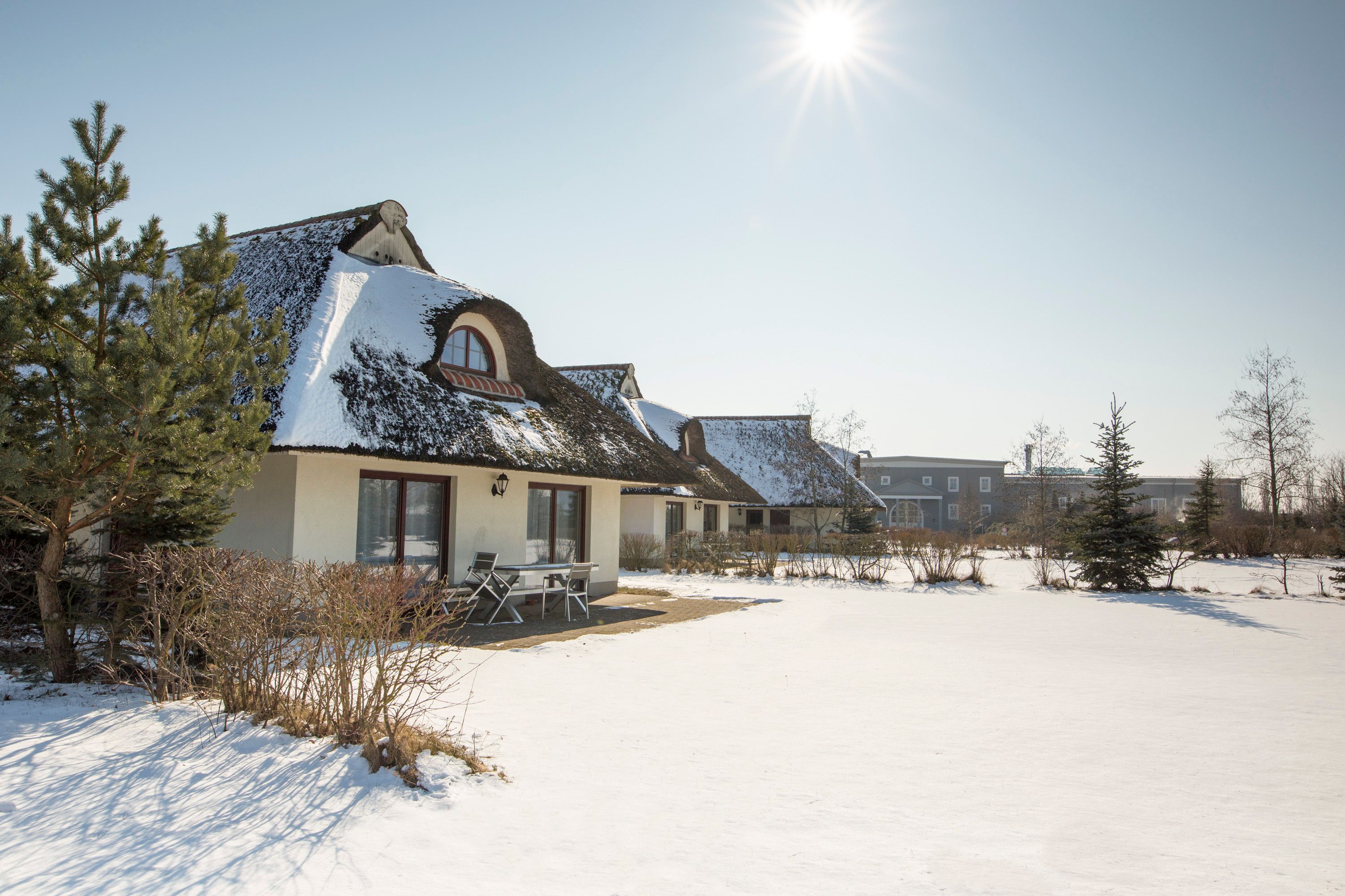 Un bâtiment recouvert de neige, doté d’un patio et surplombant un ciel dégagé.