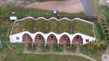 A white building with a unique curved roof and multiple arched windows.