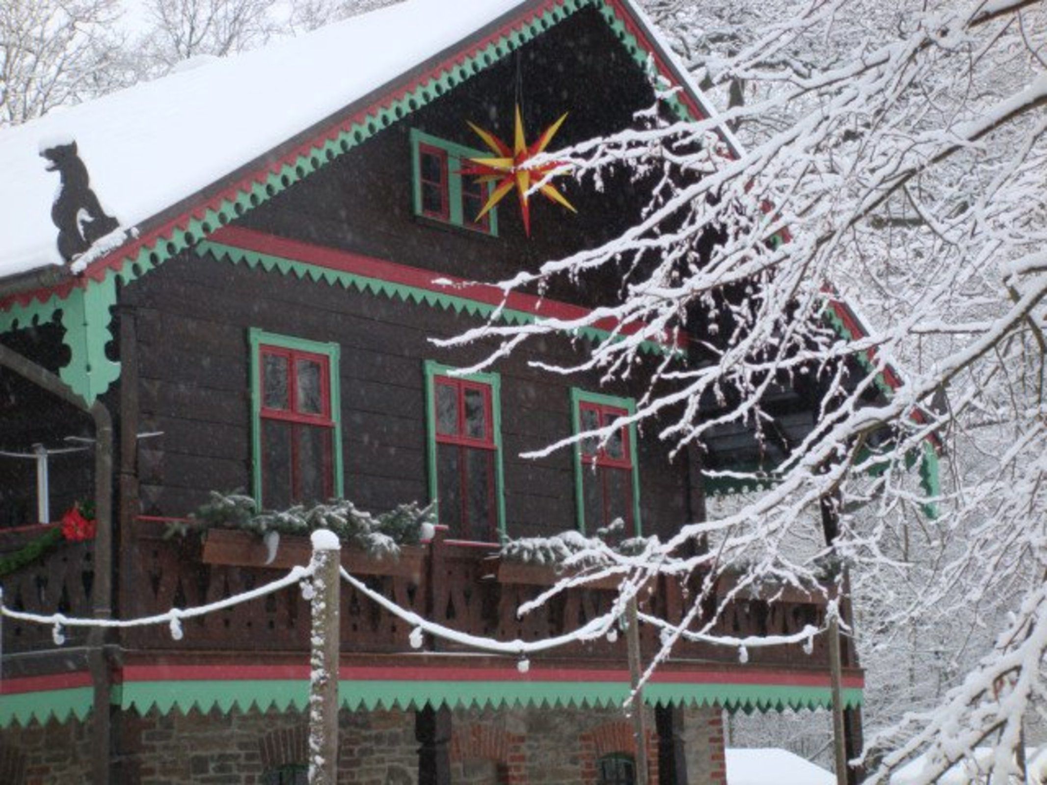Ein Holthaus mit schneebedecktem Dach und einer Sternverzierung.