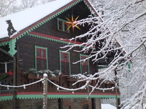 Una casa de madera con techo nevado y un adorno con forma de estrella.