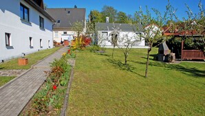 A residential property with a paved pathway, a well-maintained lawn, and a barbecue area. - House Meeresgeflüster (R) - holiday house Meeresgeflüster (Sellin)