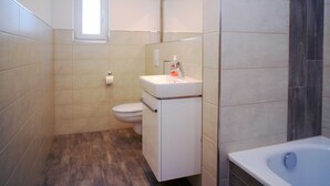 Une salle de bain avec des toilettes, un lavabo et une baignoire.