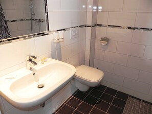 Ein Badezimmer mit Waschbecken, Toilette und Spiegel.