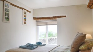 A bedroom with a bed, a window, and a wall-mounted picture frame. - Mountain View-UK11825 (Sarnau, near Brecon)