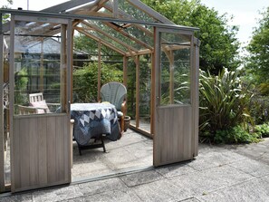 A glass greenhouse structure with a table and chairs inside. - Middle Lodge enjoys a rural, south facing setting and is a gardener’s delight. (Near Mintlaw)