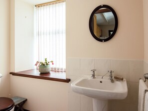A bathroom with a sink, mirror, window with blinds, and a potted plant. - Middle Lodge enjoys a rural, south facing setting and is a gardener’s delight. (Near Mintlaw)