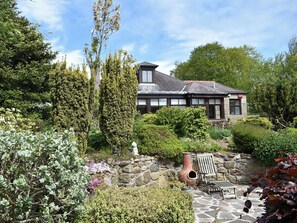 A stone wall with a bench and a rustic pot. - Middle Lodge enjoys a rural, south facing setting and is a gardener’s delight. (Near Mintlaw)