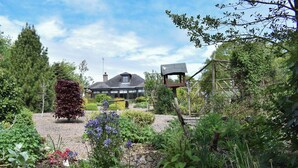 A garden with a variety of plants and a wooden structure.