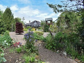 Un jardin où l’on trouve une grande variété de plantes et une structure en bois.