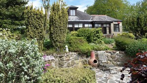 A stone wall with a bench and a rustic pot.