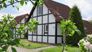 A traditional half-timbered house with a paved pathway leading to the entrance.