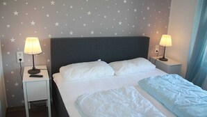 A hotel room with a bed, two bedside tables with lamps, and a wall with star decals. - Vacation rental Norway - House Nordic Dreams (Esens)