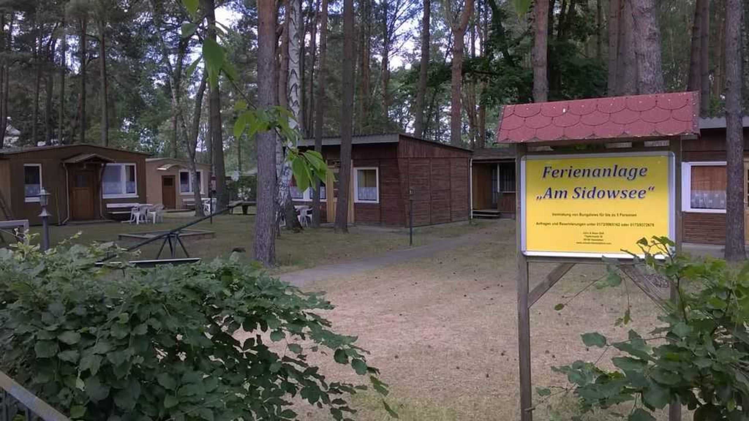 Ein Campingplatz mit Hütten und einem Schild.