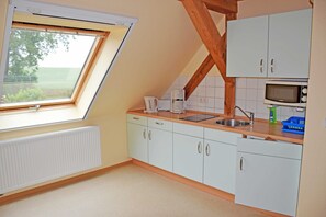 Kjøleskap, mikrobølgeovn og høy barnestol